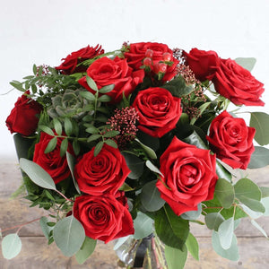 A bouquet of large red roses with beautiful foliage