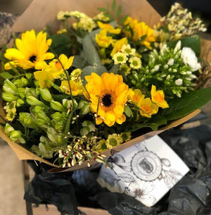 bright yellow and white flowers wrapped in paper 