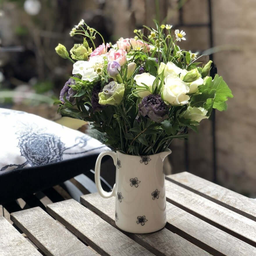 Fine bone china jug decorated with jasmine flowers filled with seasonal flowers.