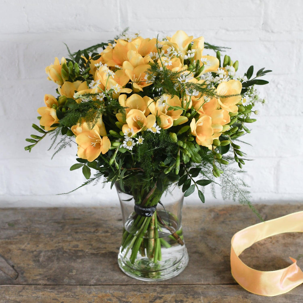 botanist bouquet of yellow freesia hand-tied in a vase.