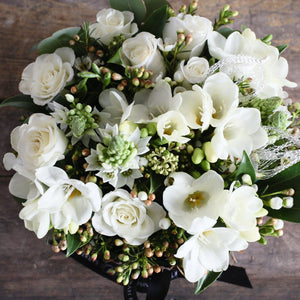 white roses, freesia and hypericum foliage