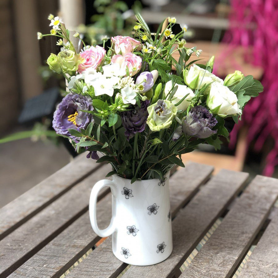 Fine bone china jug decorated with jasmine flowers filled with seasonal flowers.