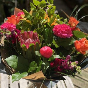 orange roses and cerise carnations with protea flowers