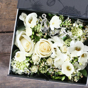 cream roses and white freesia with pale green berry foliage