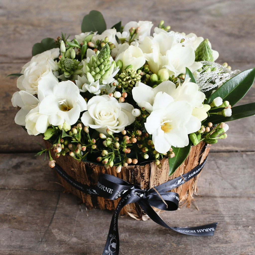 white roses, freesia and hypericum foliage