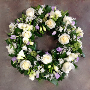Cream roses lilac lisianthus and freesia funeral wreath
