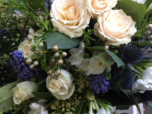 White roses. blue eryngium, and foliage  