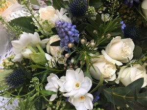 White roses. blue eryngium, and foliage  