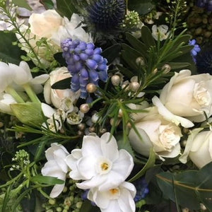 White roses. blue eryngium, and foliage  