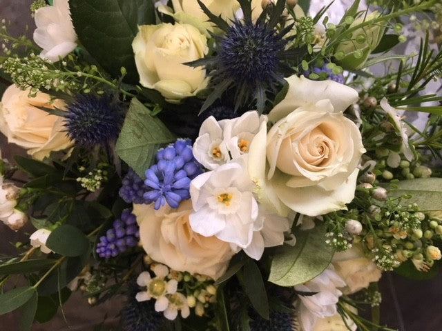 White roses. blue eryngium, and foliage  