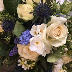 White roses. blue eryngium, and foliage  