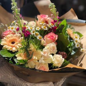 Roses, spray roses, germini and foliage wrapped in Sarah Horne paper.