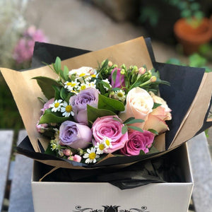 A petite hand-tied of pastel roses and foliage and gift box. 