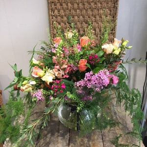 a large floral design for a plinth with lilac and peach flowers