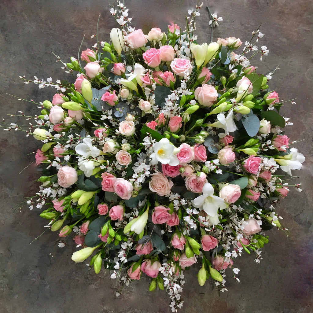 pinks spray roses and white freesia funeral posy.