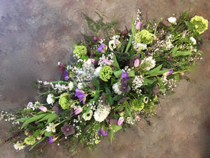 seasonal flowers in whote and lilac in a coffin spray.