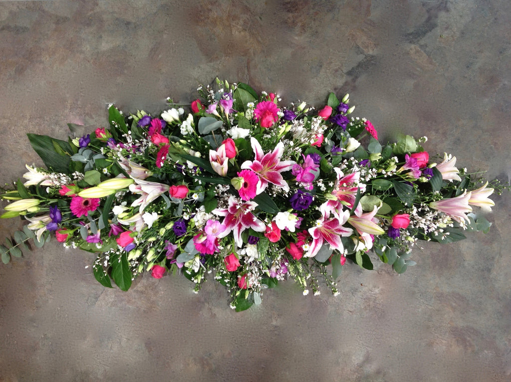 Cerise germini. pink lilies, purple lisianthus coffin spray 