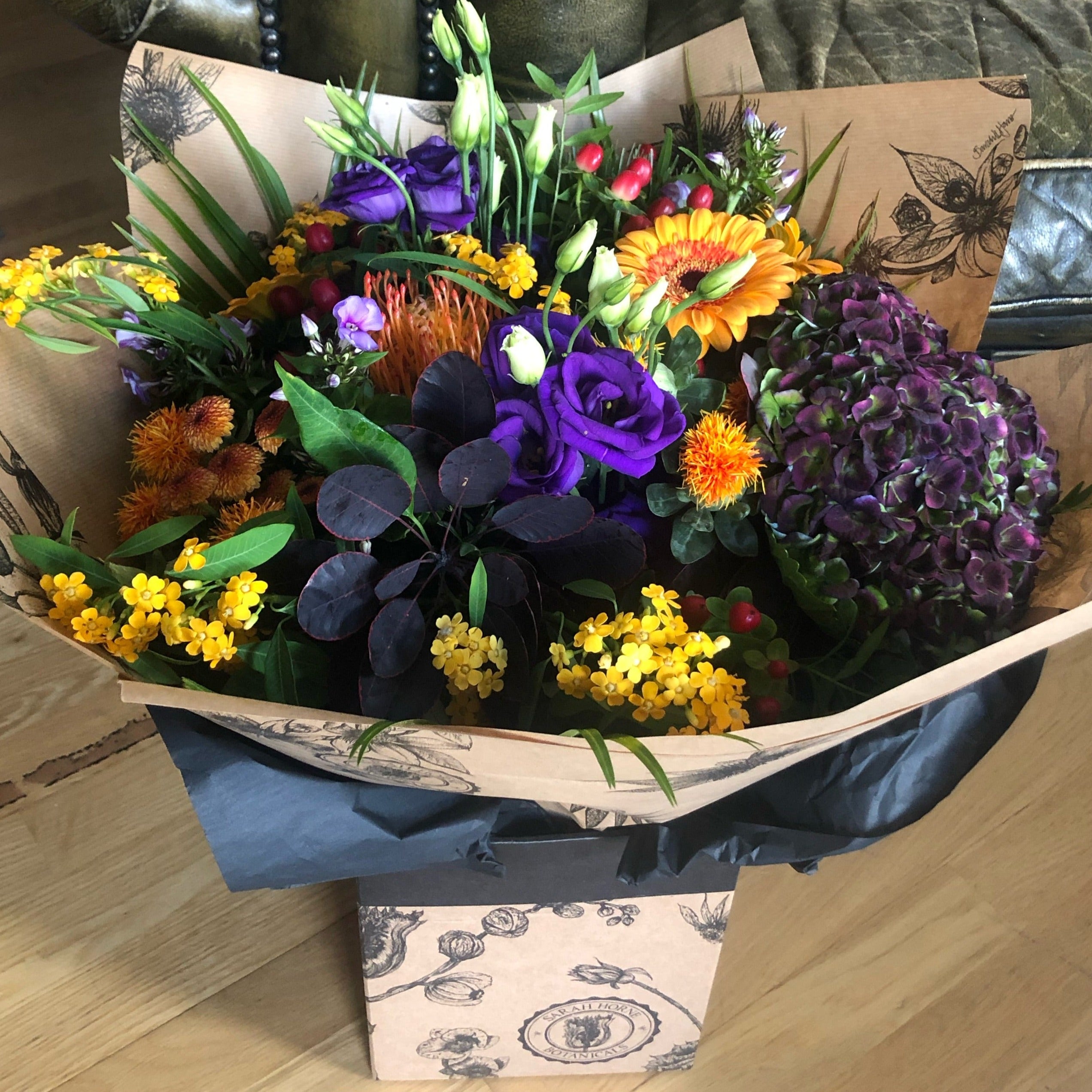 A beautiful bouquet of autumn blooms in golds, oranges and purple flowers