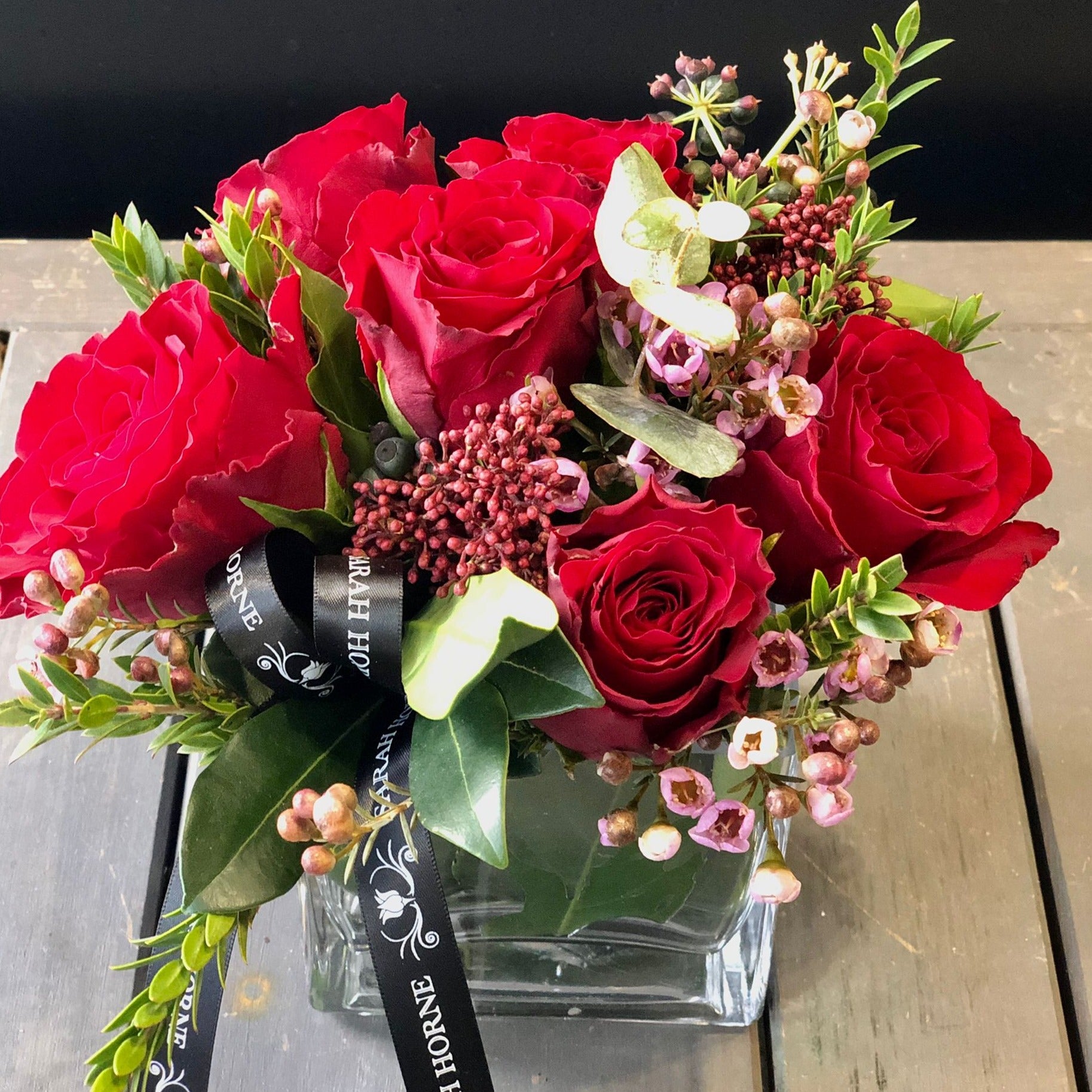 6 red roses in a cube vase