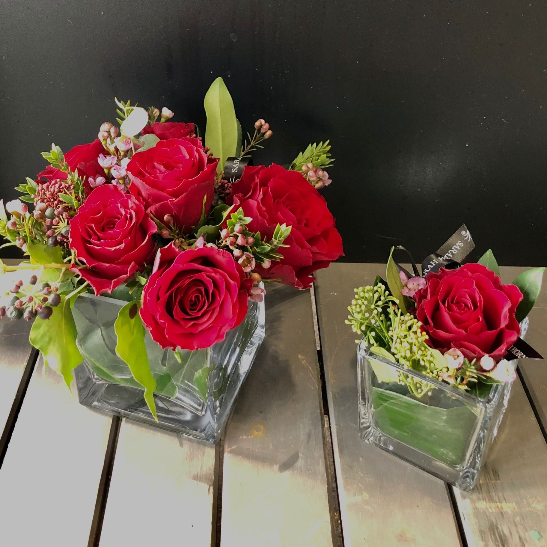 six red roses in acube vase and a single red rose in a cube vase 