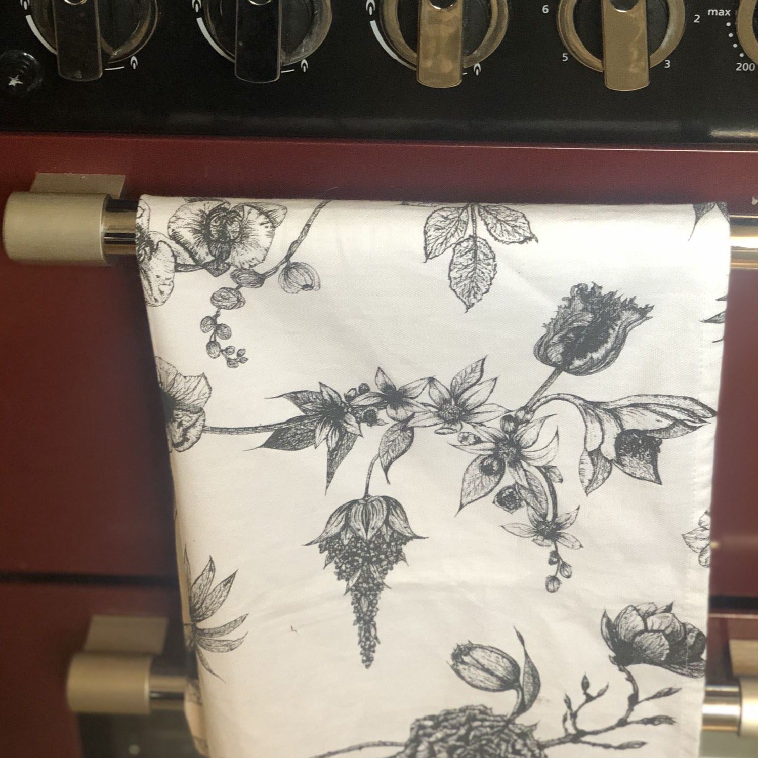 cotton tea towel hanging on a cooker door
